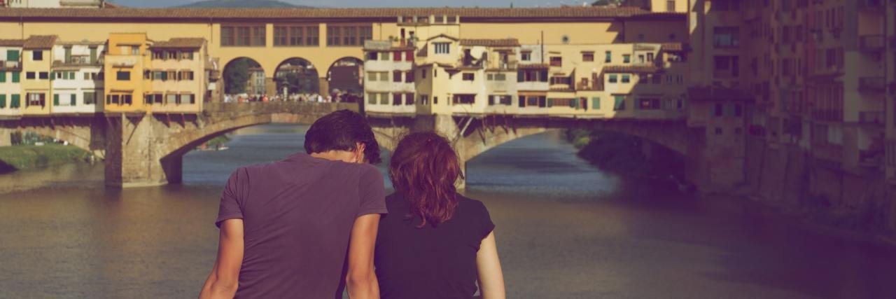 Why I Couldn't Tell My Date About My Eating Disorder photo of a couple sitting on a bridge together