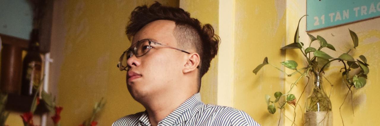 The Trauma of Being Told I Was Going to Hell for Being Gay photo of man leaning against surface looking upset