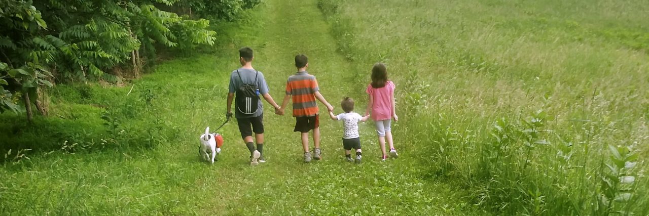 Heather's family walking in a field.