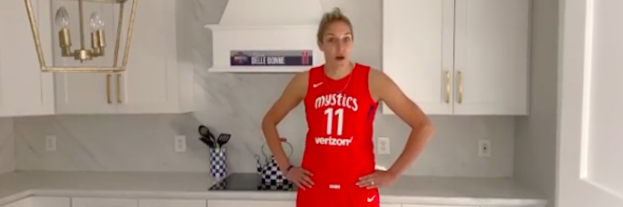 WNBA Star Elena Delle Donne Forced to Choose Between Health and Job Elena Delle Donne in her red Mystics jersey in a kitchen
