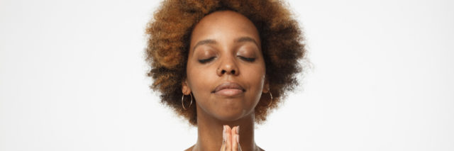 Black woman praying with eyes closed