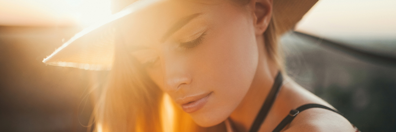 Struggling With Heat Sensitivity and MS During COVID-19 A woman with a hat in the sun