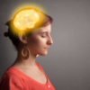 Woman thinking with glowing brain illustration.