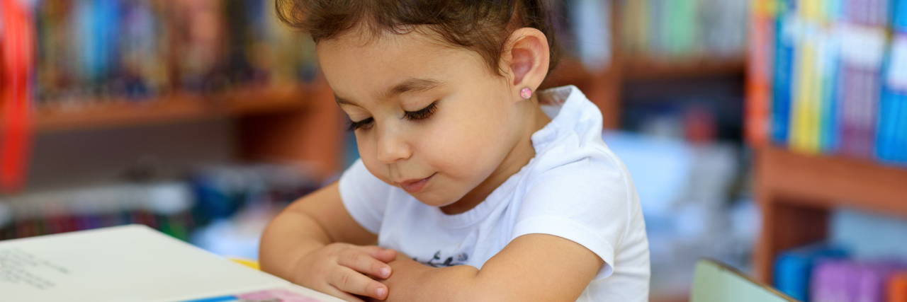 Gardiner and McKay Scholarships Help Florida Kids With Disabilities Little girl reading a book.