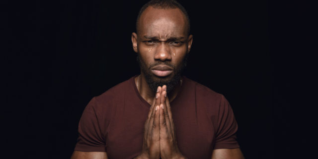 A man holding his hands in prayer