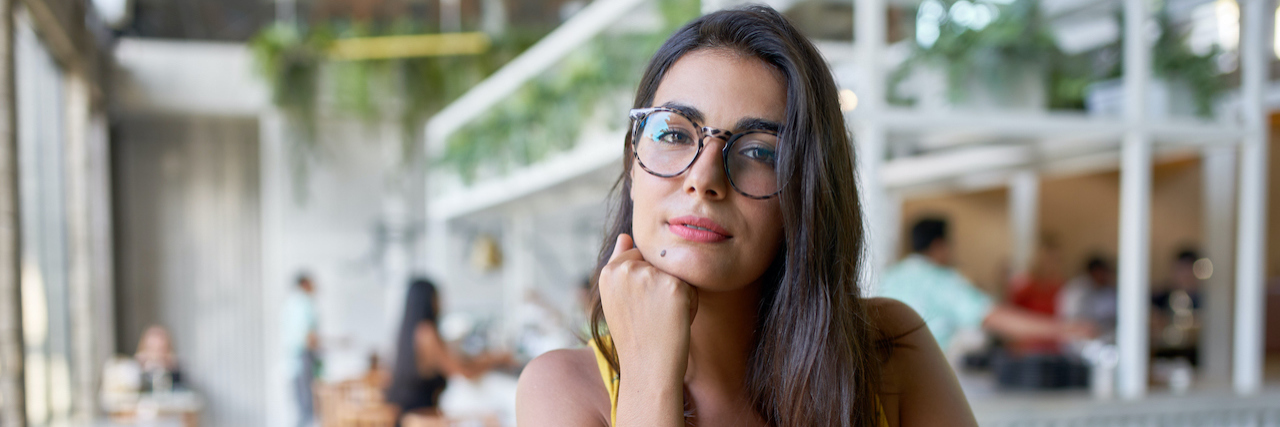 When Your Vulnerability Is Used Against You as an Abuse Survivor Young woman at cafe looking confidently at camera
