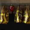 firefighter's clothing hanging in a firehouse