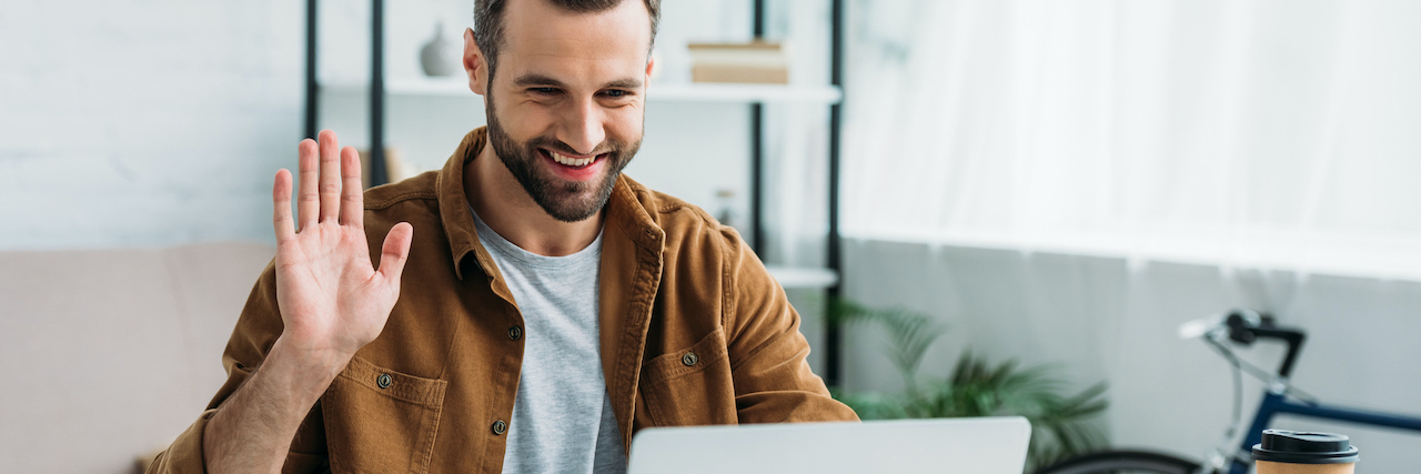 What It Was Like Playing Virtual 'Survivor' as Someone Who Stutters A man video chatting, holding his hands up