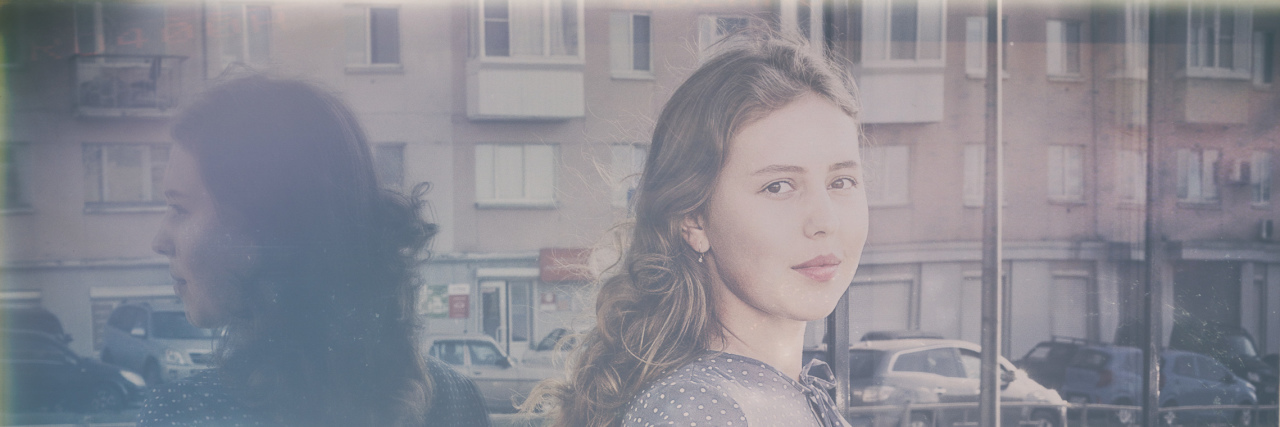 Let's Talk About Body Privilege and Disability Woman leaning against a window and wall.