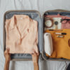 Woman's hands putting clothes into suitcase
