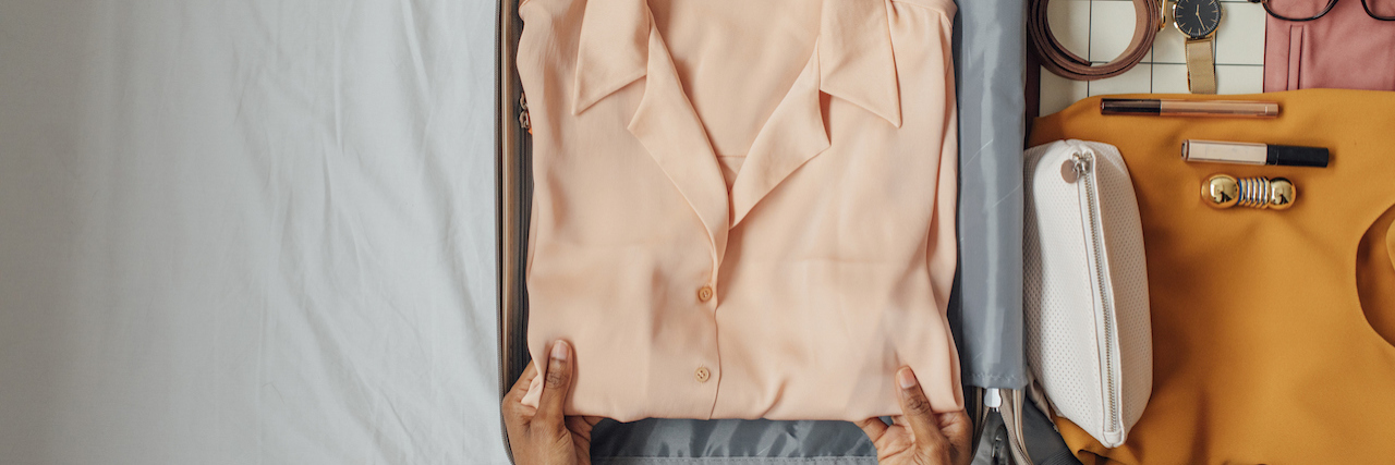 Traveling Across the World When You Have BPD Woman's hands putting clothes into suitcase