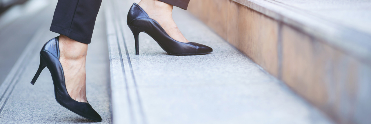 Woman in heels walking up stairs.