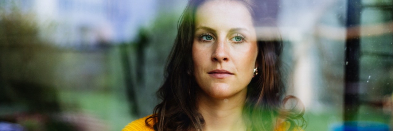 Infertility Treatment: How to Survive the Two-Week Wait Young woman looks thoughtfully and sadly through the window