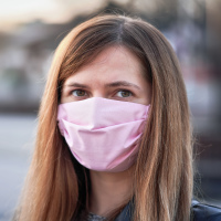 Young woman with pink hand made cotton face mask.