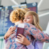 Mother and daughter hugging at airport.