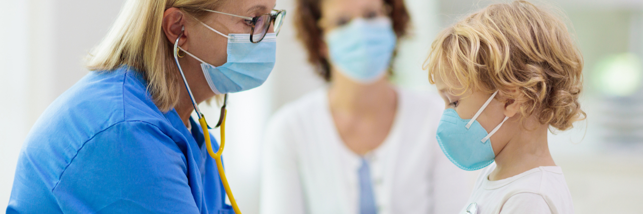 Please Be Patient With Healthcare Providers During COVID-19 Doctor examining child in face mask.