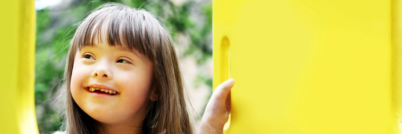 Portrait of young girl with Down syndrome on the playground
