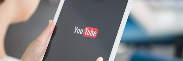 A person holding a Apple iPad Air with YouTube logo on a screen. YouTube is the world's most popular online video-sharing website that founded in February 14, 2005