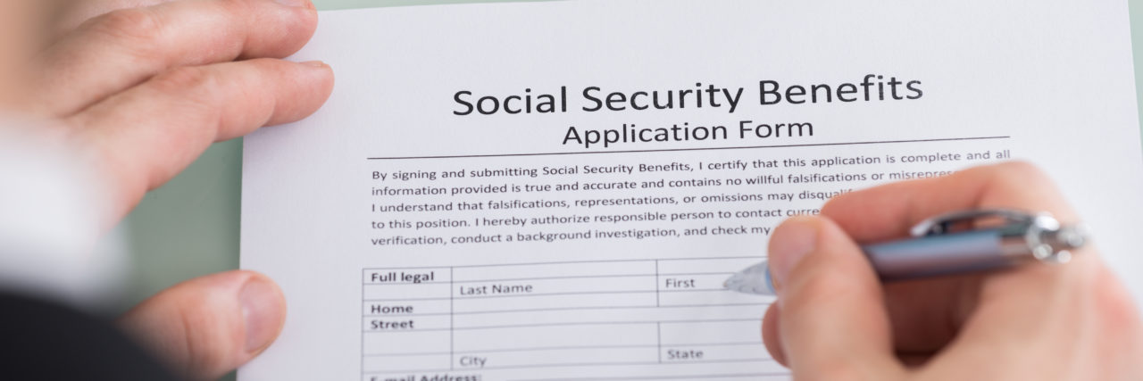 Why I Have Mixed Feelings About the ADA 30th Anniversary Person filling out social security benefits form.