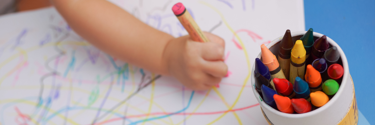 To the Kids With Autism Who Miss Going to School During COVID-19 Child drawing with crayons.