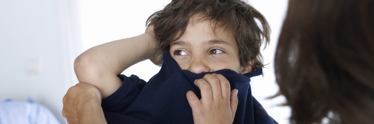 5 Things Only Parents of Kids With Sensory Issues Will Understand Mother helping child get dressed.