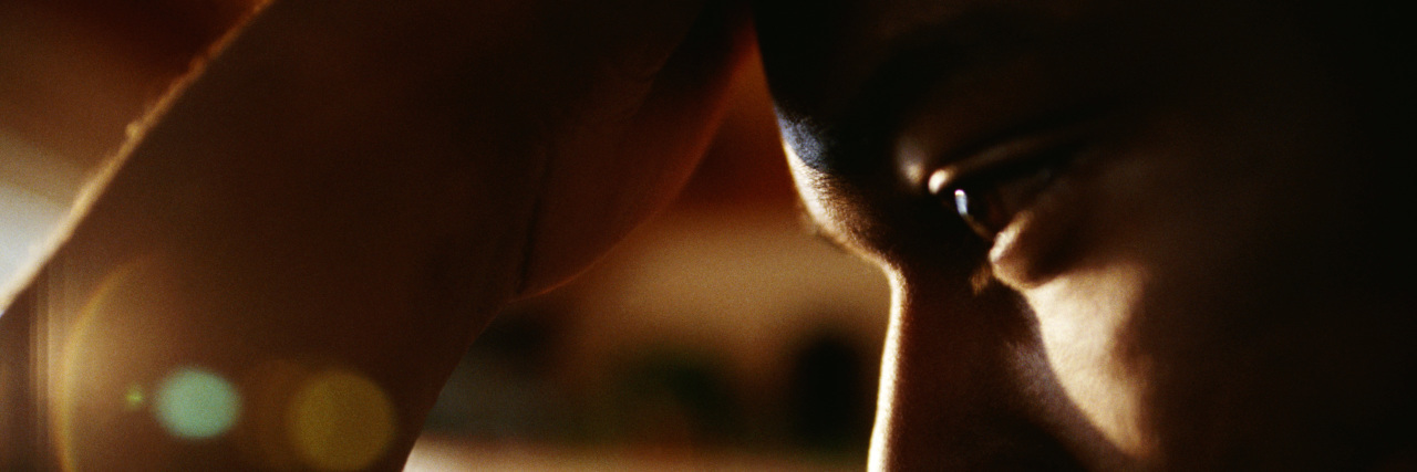 Protecting Your Mental Health During COVID-19 and a Revolution Close up of a man's face, with his hand on his head, looking serious and concerned