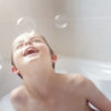 a boy is playing with bubbles in a bath