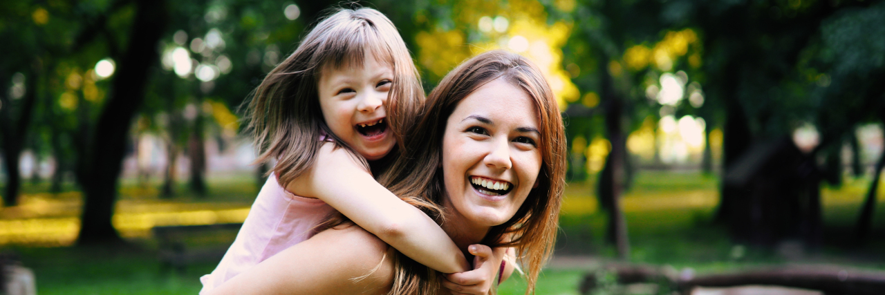 Why Spread the Word to End the Word Is So Important Girl with Down syndrome playing outside.