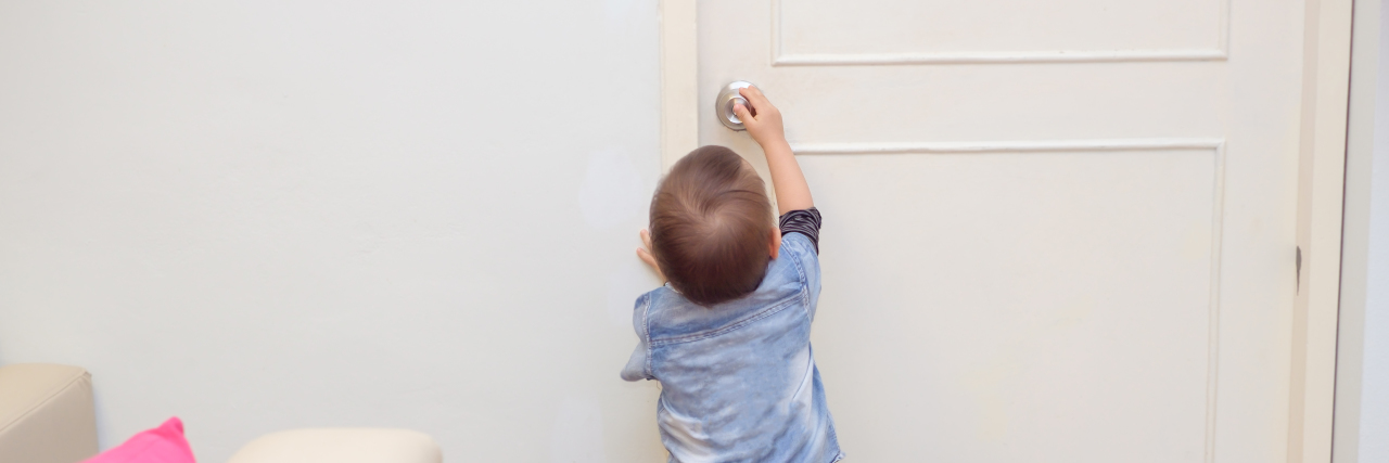 Childproofing the House for Children on the Autism Spectrum Child trying to turn doorknob.