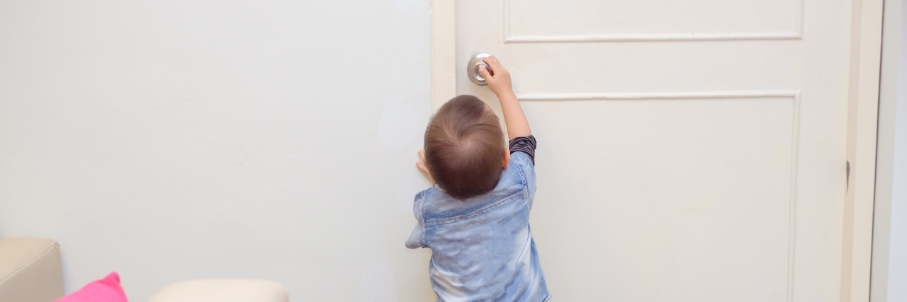 Child trying to turn doorknob.