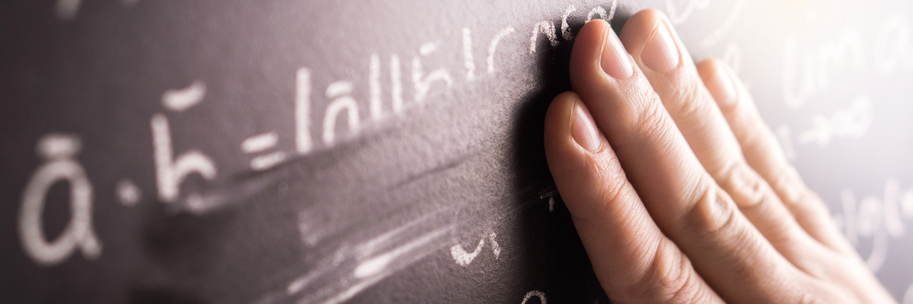 Teachers Are Writing Wills in Preparation for a New School Year A hand wiping off a math equation written in chalk on a chalk board