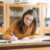 Young woman studying books in school