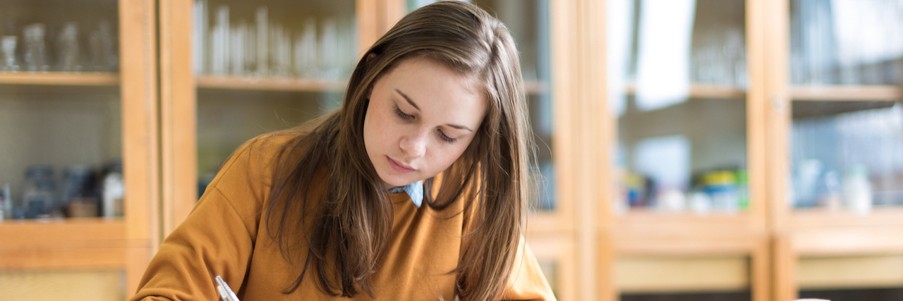 How 'Toxic Compliments' Reinforced My Eating Disorder Growing Up Young woman studying books in school