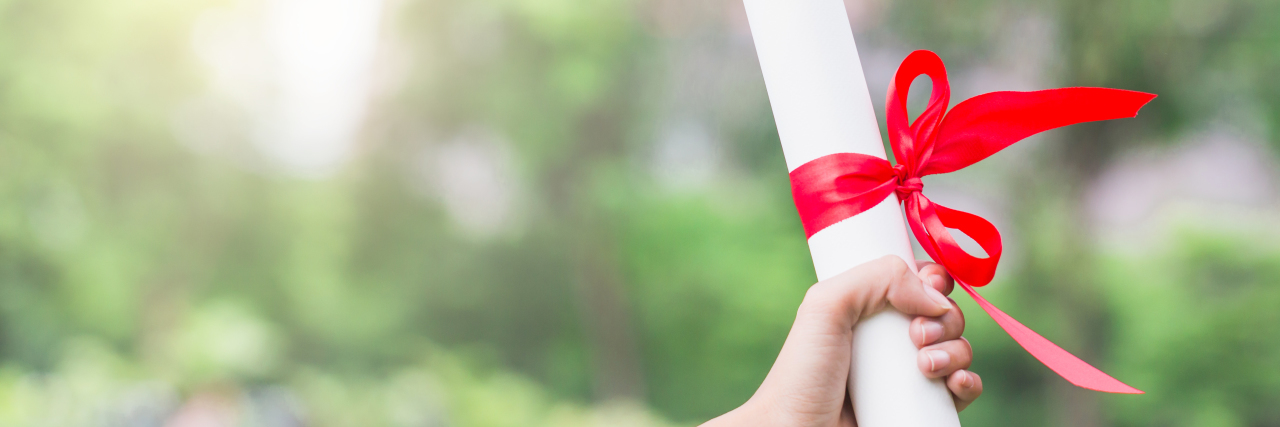 Celebrating Disability Pride Month With Learning Disabilities Woman holding diploma.