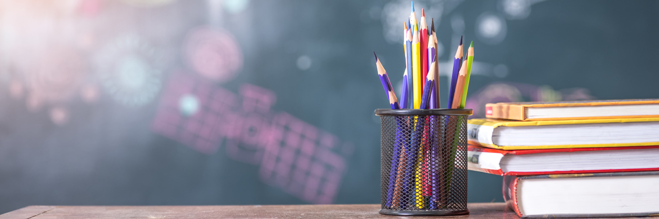 7 Common Sense Ways to Improve Education for Kids With Disabilities Book and colored pencils on school table.