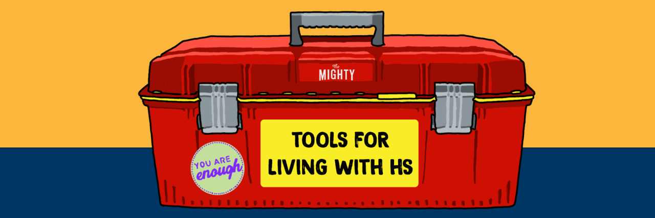 Digital illustration of a red toolkit with a label on the front that says, "Tools for Living With HS." A Mighty logo is on the lid of the toolbox. A sticker that says, "You are enough" is on the side of the toolbox.