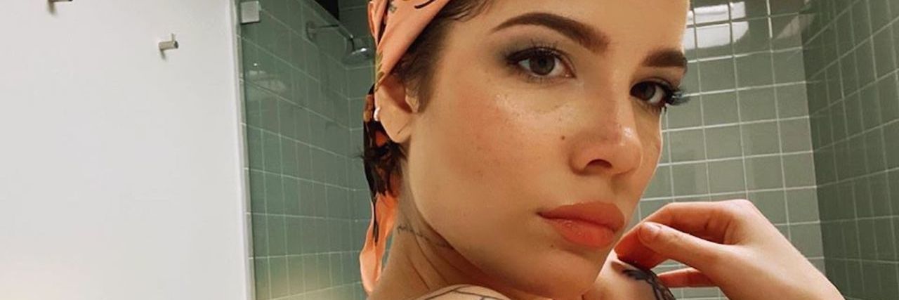 Halsey, standing in a bathroom wearing a pink-colored headband