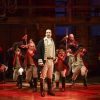The cast of 'Hamilton" performing onstage with Lin-Manuel Miranda at the center