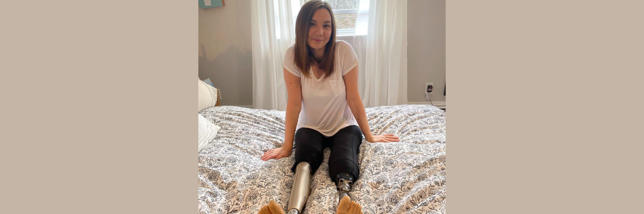 My Journey From Shame to Self-Love After Losing My Legs Stefanie sitting on her bed.