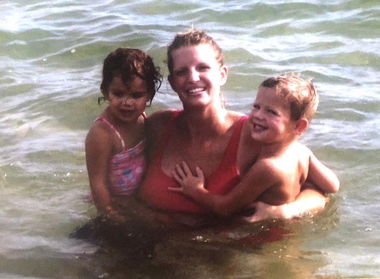 Julie in the ocean with her son and daughter.