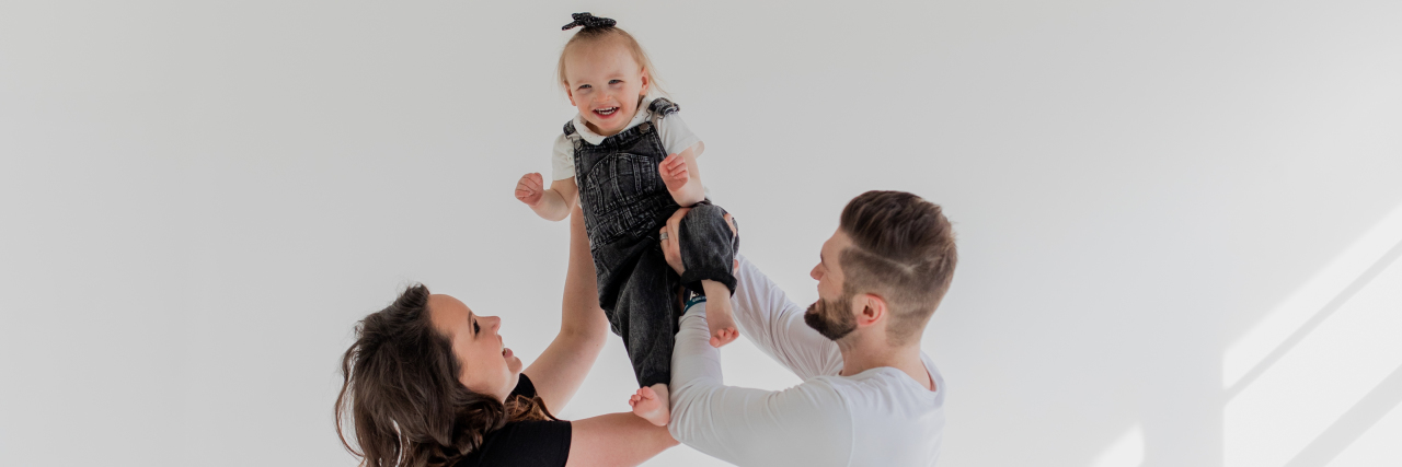'Welcome to Holland' Parenting a Child With Cri Du Chat Syndrome Jackie and her husband holding up their daughter.