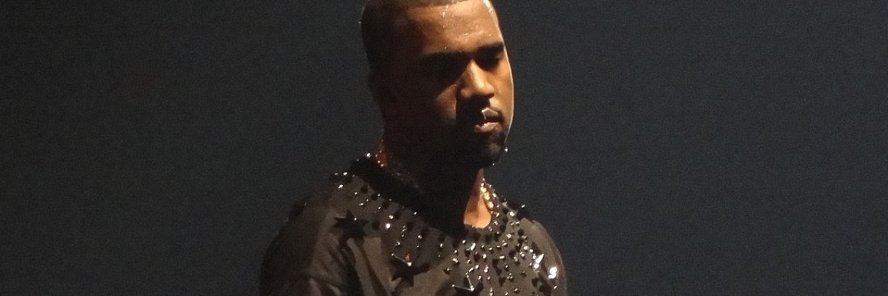photo of Kanye West on tour in the Netherlands, wearing a dark gray shirt with black stars