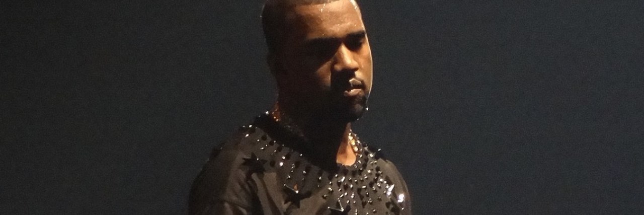 Kanye West Breakdown Coverage Has Been Triggering for My Mental Health photo of Kanye West on tour in the Netherlands, wearing a dark gray shirt with black stars