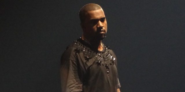 photo of Kanye West on tour in the Netherlands, wearing a dark gray shirt with black stars