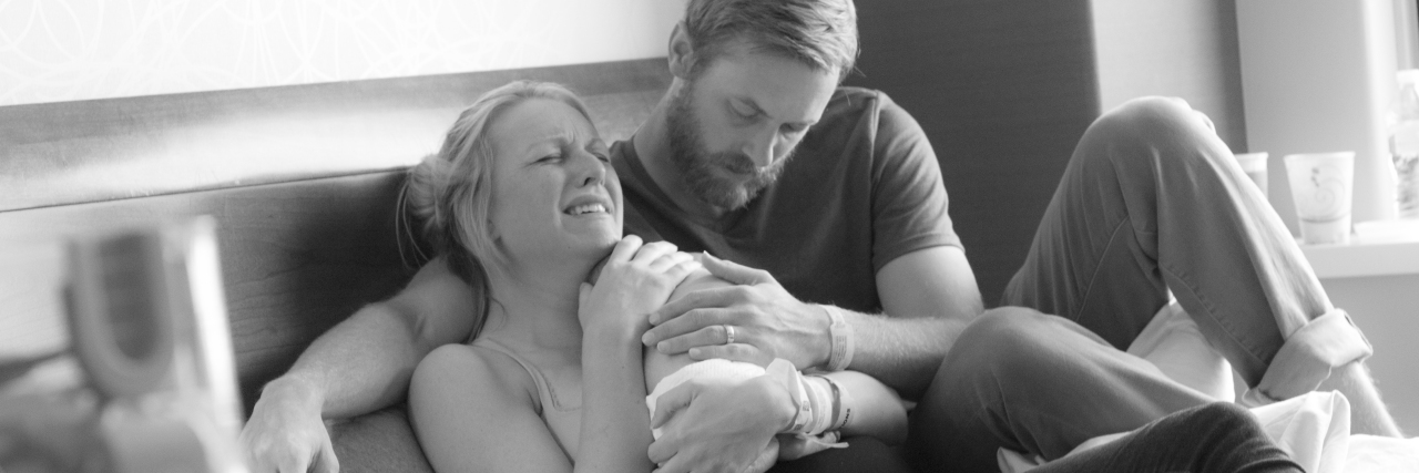 Surviving Birth Trauma — Four Years Later A baby being cradled by his mom who is crying and his dad.