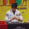 Max Park, a teenager with dark hair, solves a Rubik's cube at a table