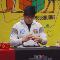 Max Park, a teenager with dark hair, solves a Rubik's cube at a table
