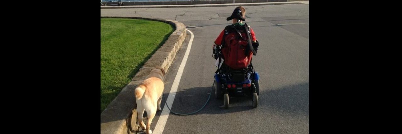 6 Lessons From Our Family Dog's Heartbreaking Death A dog walking alongside a young man in a wheelchair
