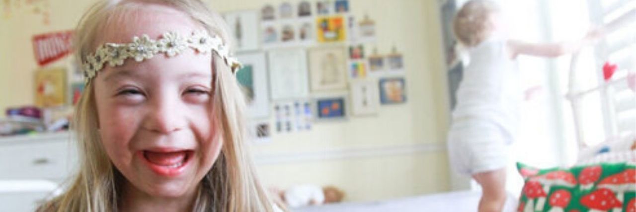 10 Down Syndrome Blogs You Should Be Following a young girl with Down syndrome smiling