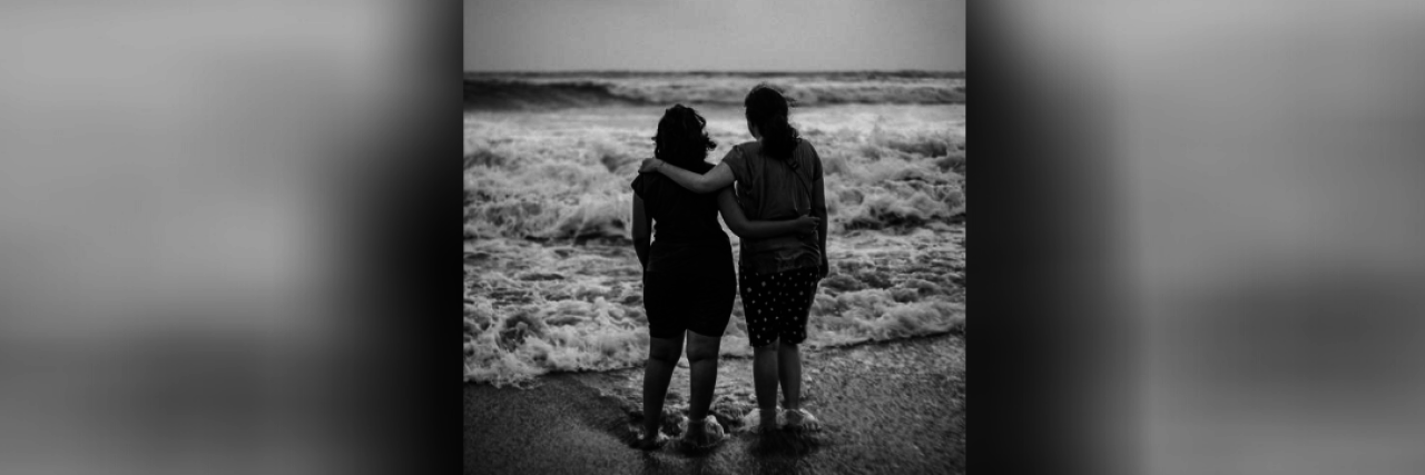 Supporting a Loved One During a Panic Attack Two friends on a beach looking out over the water